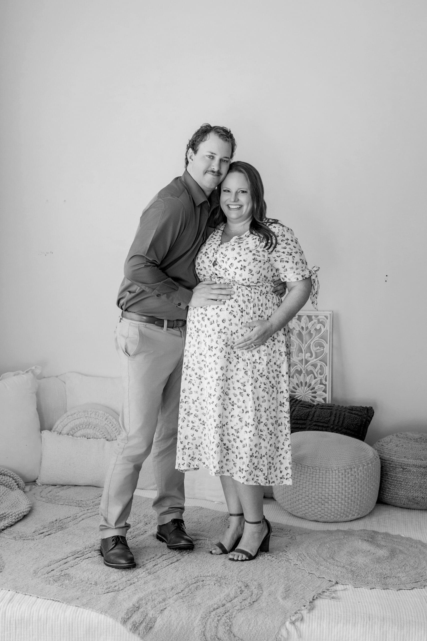 expecting couple holding baby bump during maternity photography session