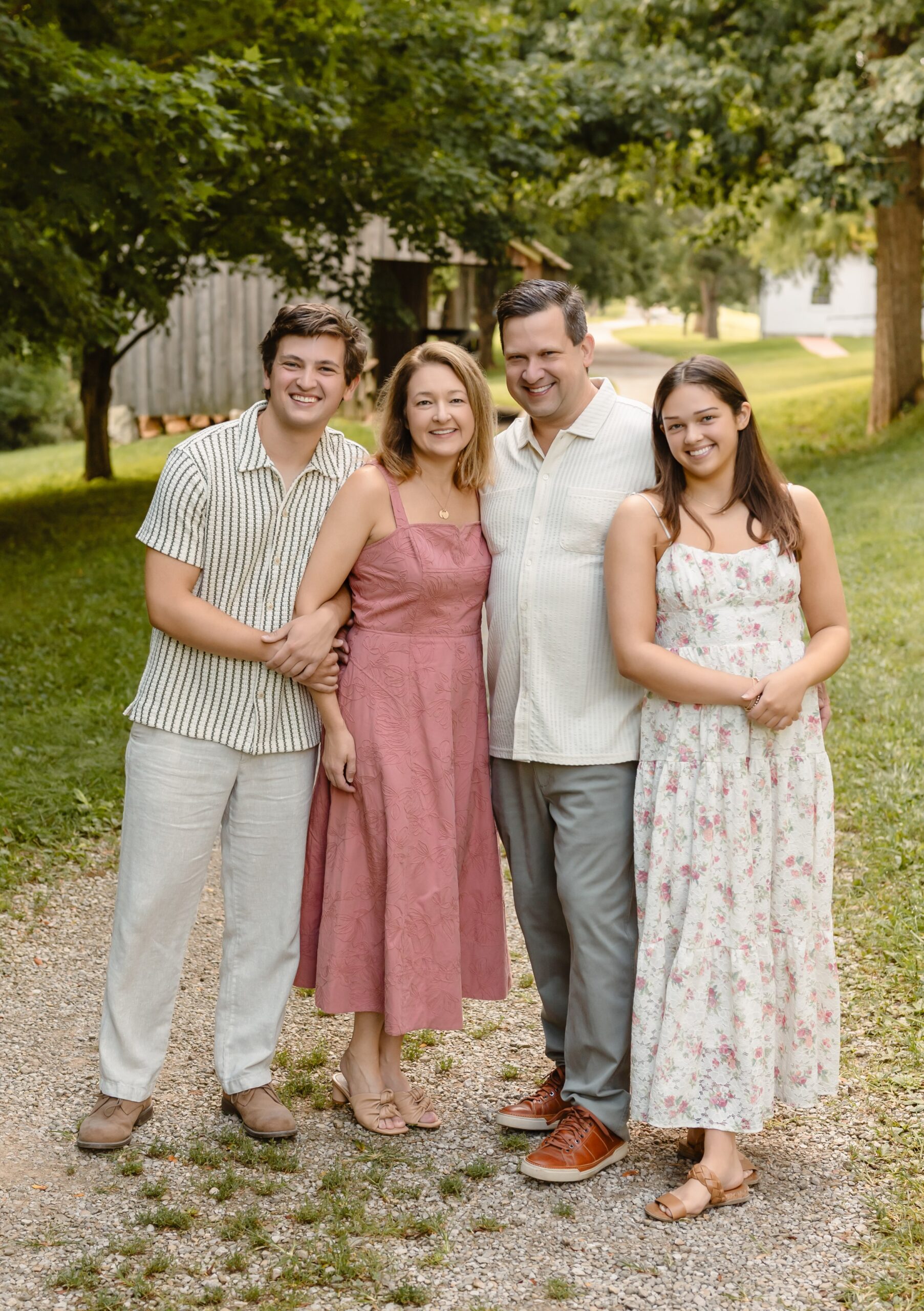 Family standing together in a St. Louis park wearing coordinated outfits during a family photography session